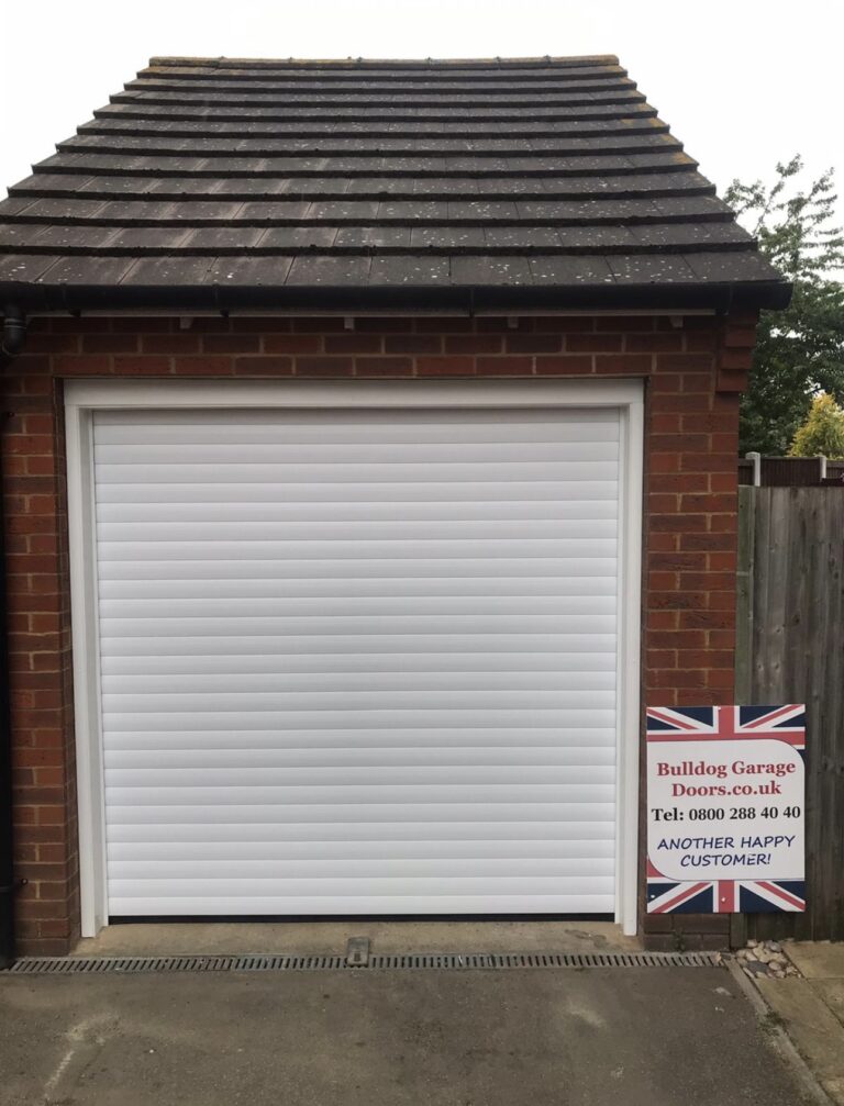 Bulldog Garage Door with frame installed in a garage building with an advertising sign stating another happy customer