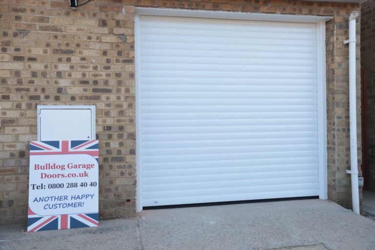 White Roller Grage Door, closed with advertising board outside stating Another Happy Customer for Bulldog Garage Doors who installed this.